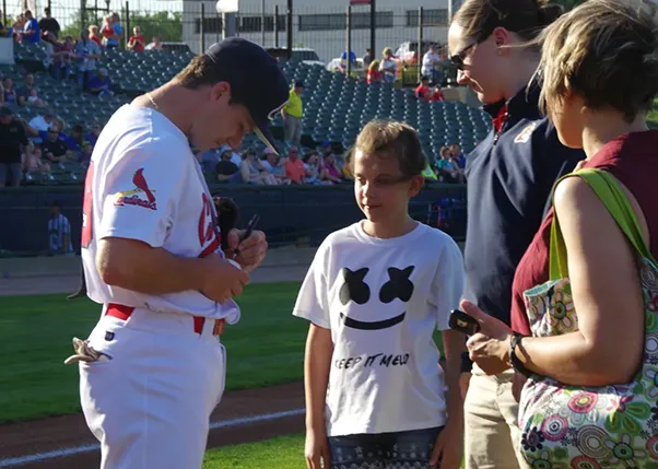 Baseball player signing kids baseball