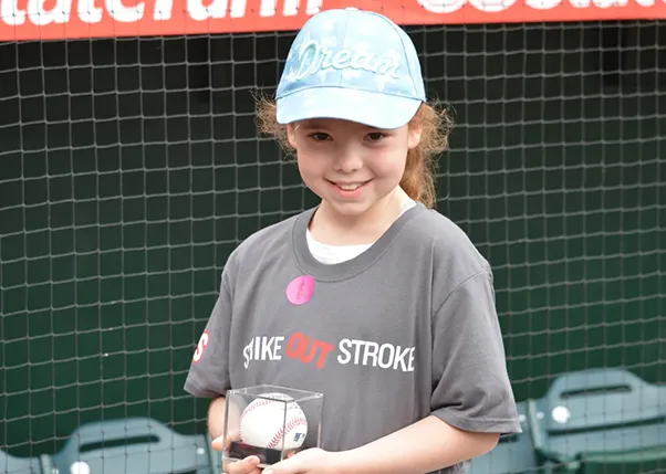 Young girl holding a signed baseball in a case