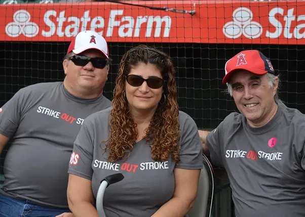 Three people wearing strike out stroke t-shirts smiling for the camera