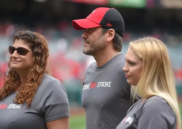 Stroke survivors and strike out stroke event organizers standing on baseball field