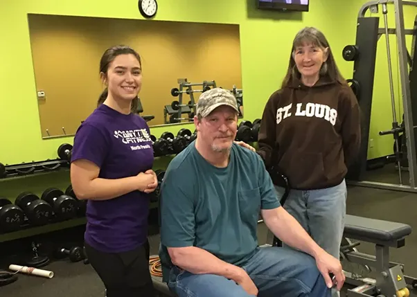 Photo of Stroke Survivor in Anytime Fitness with His Personal Trainer and Caregiver